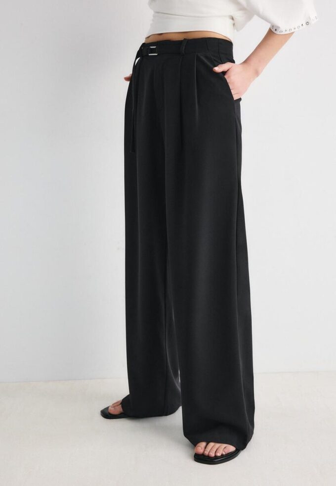 Bukser med vid ben og spennedetaljer