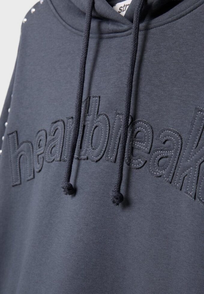 Hettegenser med nitter og broderi