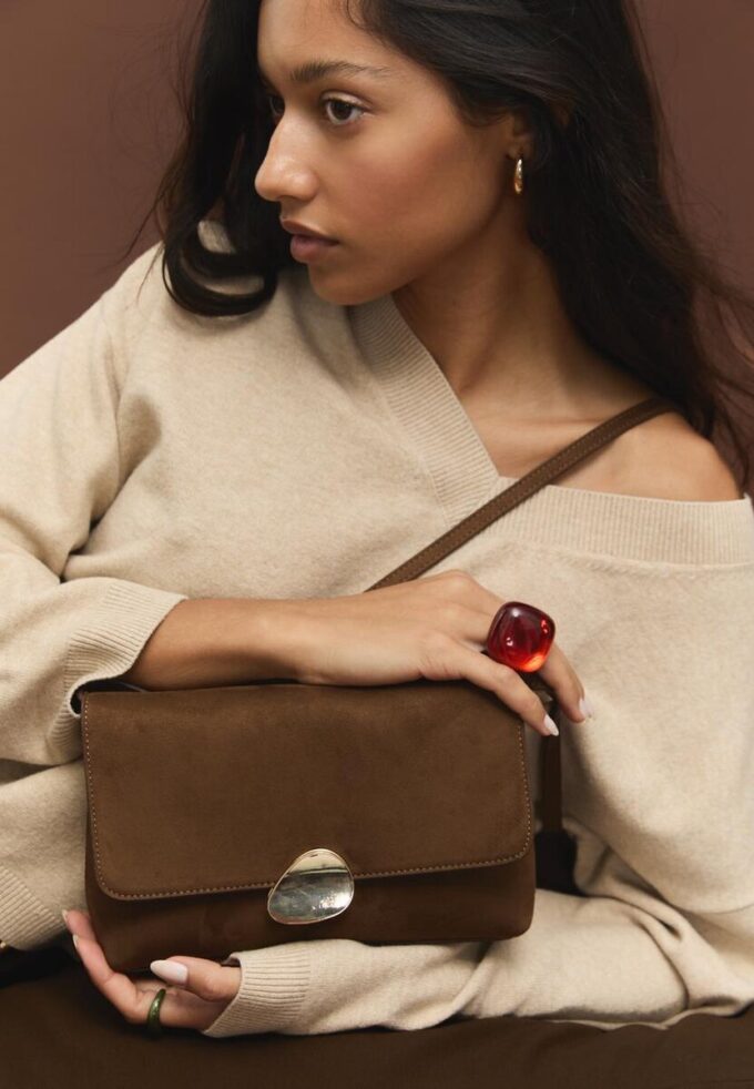 Veske i imitert semsket skinn med asymmetrisk metallspenne